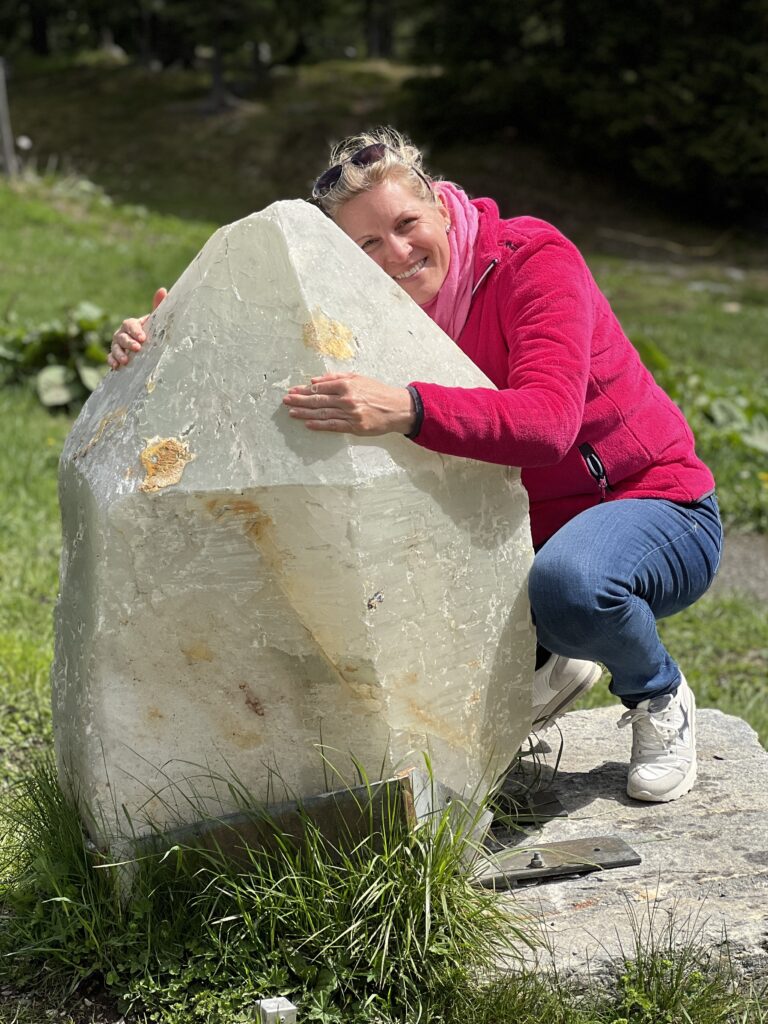 Yvonne Heckmann umarmt einen großen Stein.